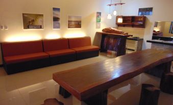 a large , empty room with a long wooden table and several chairs , all set against white walls at Wisma BPI