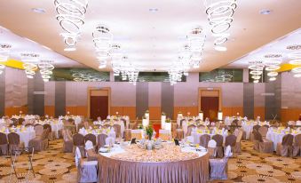 a large banquet hall with multiple round tables set for a formal event , surrounded by chairs at Palm Seremban Hotel