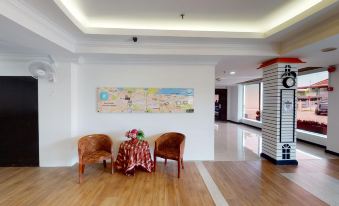 The room features a large table and chairs adjacent to the living area, which is adorned with artwork at Golden Hotel