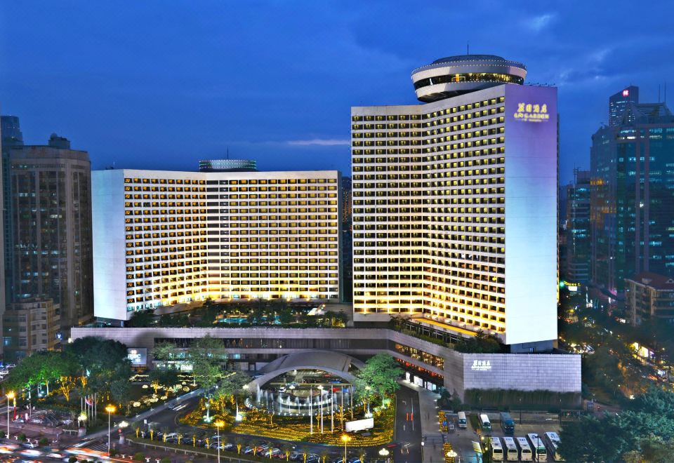 At night, a large building with numerous windows in the center is illuminated by streetlights at LN Garden Hotel Guangzhou