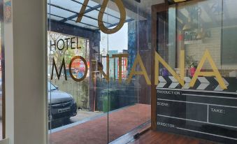 a modern hotel entrance with a large glass door and a car parked outside at Hotel Montana