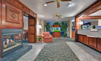 a hotel lobby with a large fish tank in the center , surrounded by chairs and couches at Holiday Inn Express Mackinaw City