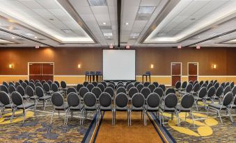 a large conference room with rows of chairs arranged in a semicircle , and a projector screen on the wall at Courtyard by Marriott Los Angeles Pasadena/Monrovia