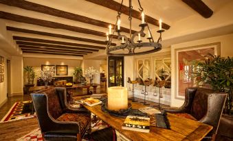 a modern , spacious living room with wooden beams and stone floors , featuring a dining table , couches , and a bar area at The Wigwam