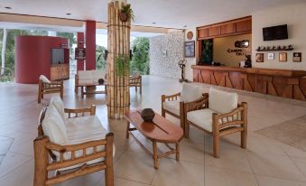 a large , well - lit room with wooden furniture and a reception desk in front of a window at Camino Real Tikal‎