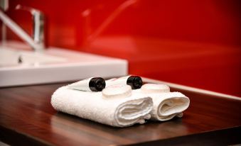 a bathroom sink with two white towels neatly folded on top of it , accompanied by a toothbrush and a soap dispenser at Hobart Tower Motel