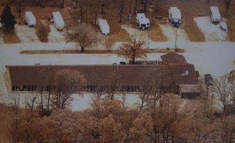 aerial view of a parking lot with multiple rvs parked , surrounded by trees and a building at Hidden Lake Resort