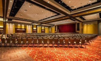 a large , empty conference room with rows of chairs and a red carpeted stage in the background at Four Winds Casino Resort – New Buffalo