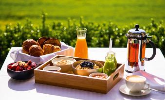 a wooden tray with a variety of food items , including sandwiches , bread , and a cup of coffee at The Louise