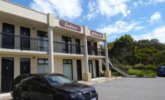 "a car is parked in front of a hotel with the name "" jackeens motor inn "" above it" at Jacksons Motor Inn