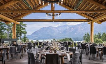 a large wooden building with tables and chairs set up for a formal event , with a beautiful mountain view in the background at Skamania Lodge