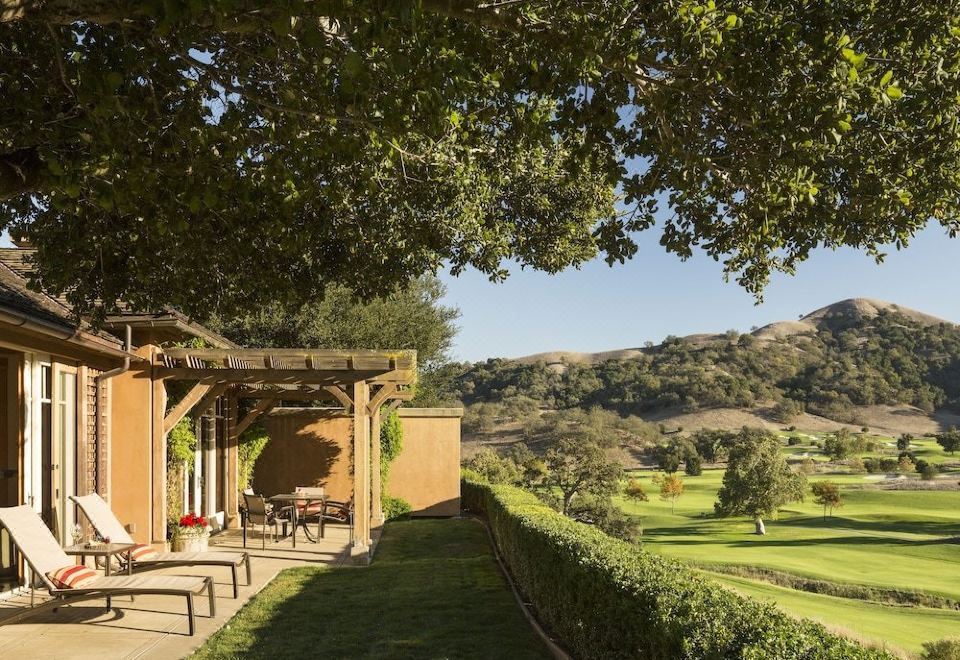 a man and a woman sitting outside on a patio , enjoying the view of a golf course at CordeValle