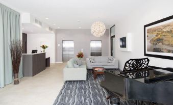 a modern living room with a large flat - screen tv mounted on the wall , a couch , and a dining table at Quest Highbrook