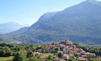 a small town surrounded by mountains , with a church at the top of the hill at Bellavista