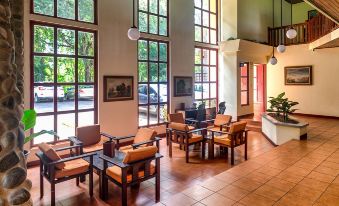 a spacious room with large windows , wooden furniture , and plants , providing a comfortable environment for meetings or meetings at Hotel Playa Bejuco