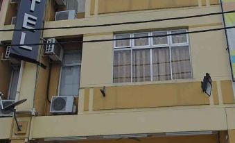 a window with white curtains and air conditioning units on the outside of a building at Adamson Inn Penang
