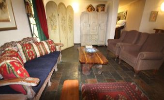 a living room with a couch , chair , and coffee table in front of an arched door at The Guesthouse