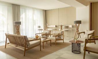 a modern living room with wooden furniture , including a couch , chairs , and a coffee table at Villa Le Blanc Gran Melia