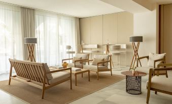 a modern living room with white walls , wooden furniture , and large windows , creating a spacious and inviting atmosphere at Villa Le Blanc Gran Melia