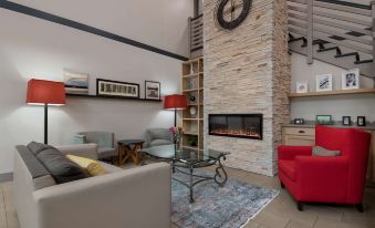 a living room with a fireplace , couches , chairs , and a rug on the floor at Country Inn & Suites by Radisson, Harrisburg Northeast - Hershey