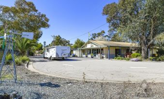 a building with a round entrance and two parked rvs in front of it , under a clear blue sky at Shepparton Holiday Park and Village