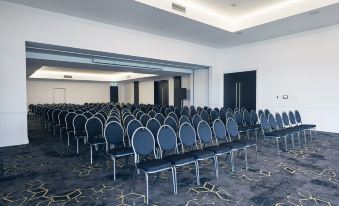 a large conference room with rows of chairs arranged in a semicircle , ready for a meeting or event at Daydream Island Resort