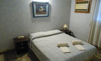 a bedroom with a bed , nightstand , and framed picture on the wall , giving it a cozy and inviting atmosphere at Hotel San Francisco