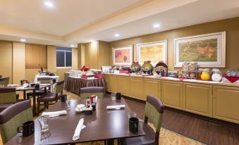 a dining area with several tables and chairs , as well as a buffet table filled with various food items at Holiday Inn Dublin - Pleasanton, an IHG Hotel