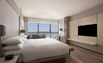 elegant wooden nightstand with a lamp on top, creating a serene and bright atmosphere at Shantou Marriott Hotel