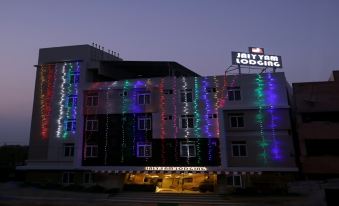 "a large building with colorful lights and a sign that says "" jaytec lodging "" in front" at Jayam