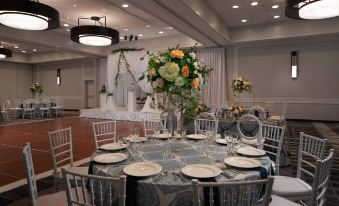 a beautifully decorated dining room with a round table set for a wedding reception , surrounded by chairs at Tysons Corner Marriott