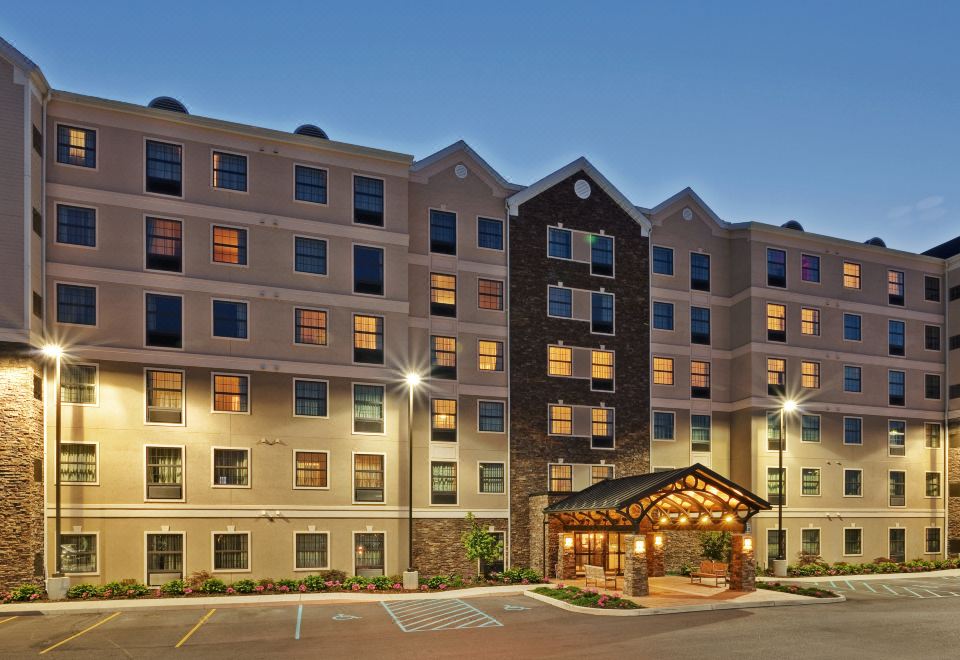 a large building with a brown sign and several windows is lit up at night at Staybridge Suites Buffalo