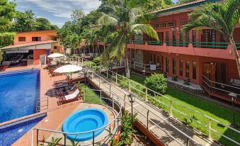 a courtyard with a swimming pool surrounded by lounge chairs and umbrellas , creating a relaxing atmosphere at Hotel Playa Bejuco