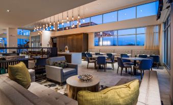 a modern hotel lobby with various seating options , including couches and chairs , as well as a dining area at Best Western Plus Executive Residency Austin