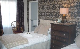 a room with two beds , one on the left and one on the right side of the room at George Inn