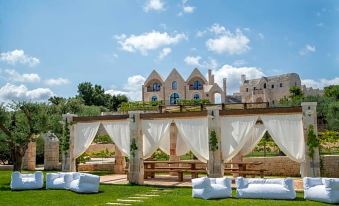 a beautiful outdoor setting with a wedding ceremony taking place on a grassy field , surrounded by white tents and greenery at Ottolire Resort