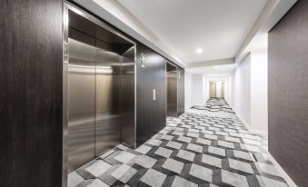 a hallway with two elevators , one on the left side and the other on the right side at The Milton Brisbane