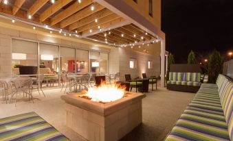 an outdoor patio with a fire pit surrounded by couches and chairs , creating a cozy atmosphere at Home2 Suites by Hilton Youngstown West/Austintown