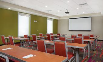 a conference room with rows of chairs arranged in a semicircle around a long table at Home2 Suites by Hilton Youngstown West/Austintown