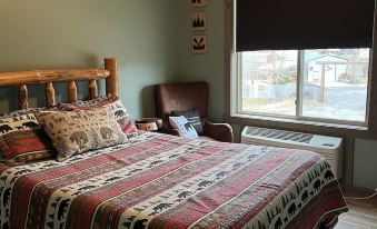 a cozy bedroom with a wooden bed , pillows , and curtains , near a window with a view of the outdoors at Rays Place Inn