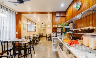 a dining room with wooden walls , tables , chairs , and a buffet table filled with various food items at Infinity Copacabana, Ex-APA Hotel