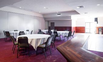 a conference room with several tables and chairs , a whiteboard on the wall , and a red carpet at Nightcap at Wanneroo Tavern