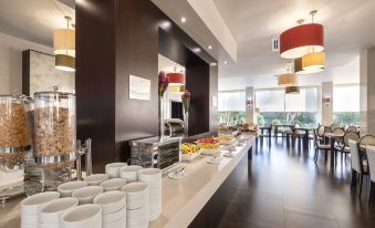 a modern dining area with a long table filled with various food items and utensils , creating a welcoming atmosphere for guests at Hotel Vale Do Navio