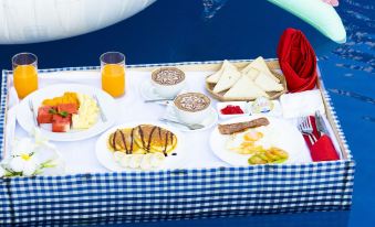 a table is set with a variety of food items , including pancakes , coffee , and juice at Vimean Sovannaphoum Resort