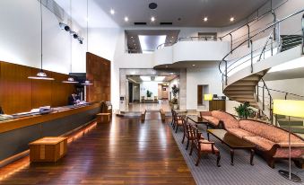 a modern hotel lobby with hardwood floors , a reception desk , and multiple chairs arranged around it at Sun Palace Hotel