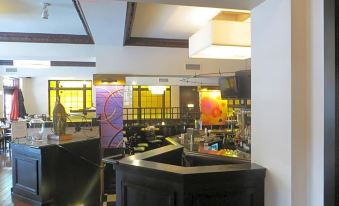 a modern bar with black and white tiles , a large screen tv , and a variety of colorful artwork at Carleton of Oak Park