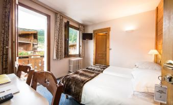 a hotel room with two beds , a television , and a window overlooking a mountainous landscape at Hotel Christiania