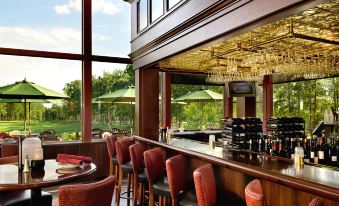 a well - lit restaurant with wooden furniture , tables , and chairs , as well as a bar area at Atkinson Resort & Country Club