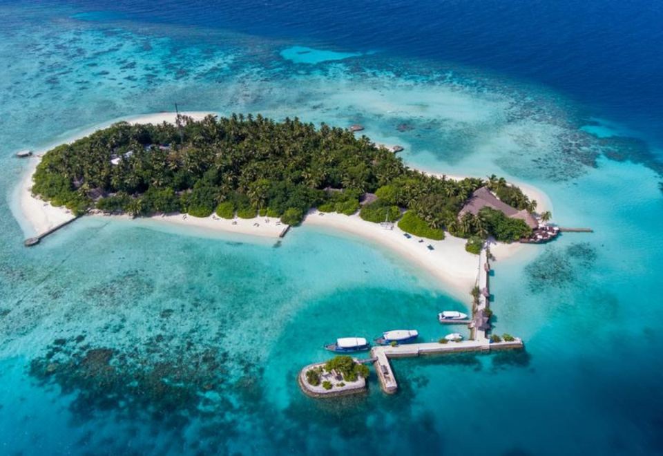 a picturesque island with a sandy beach , clear blue water , and lush green vegetation , surrounded by a resort at Makunudu Island