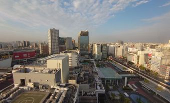 a cityscape with a large , modern building in the center and several smaller buildings surrounding it at Kawasaki Nikko Hotel